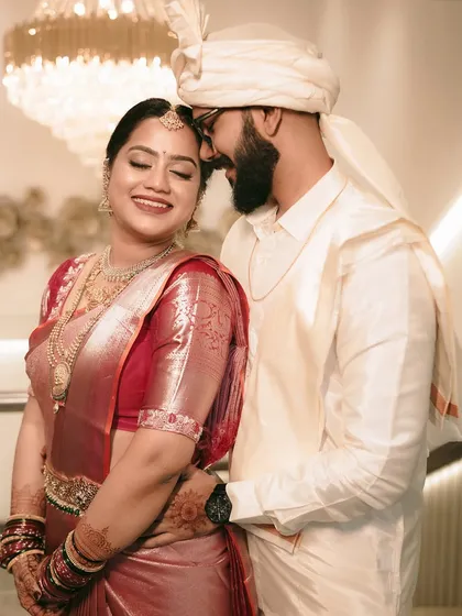 A tender moment between a South Indian couple, their smiles reflecting the joy of their wedding day.