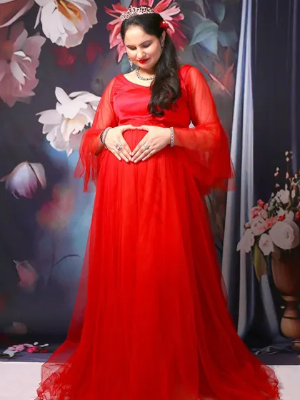 A sweet solo pose where the mom-to-be makes a heart shape with her hands on her belly.