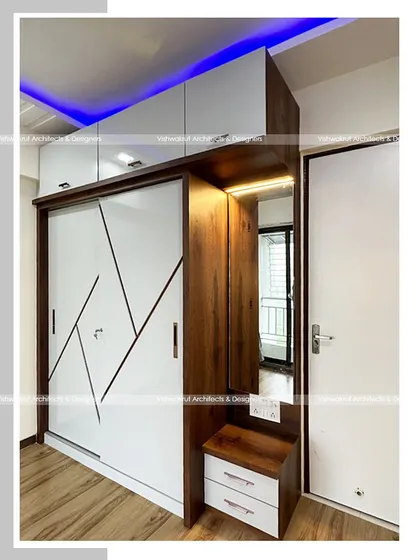 A custom wardrobe with an integrated dressing unit. The design includes a full-length mirror and drawers, combining two essential bedroom functions into one sleek piece of furniture to save space.