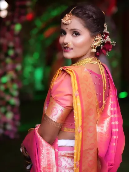 A back profile of the bride, showcasing her floral bun and the design of her blouse.