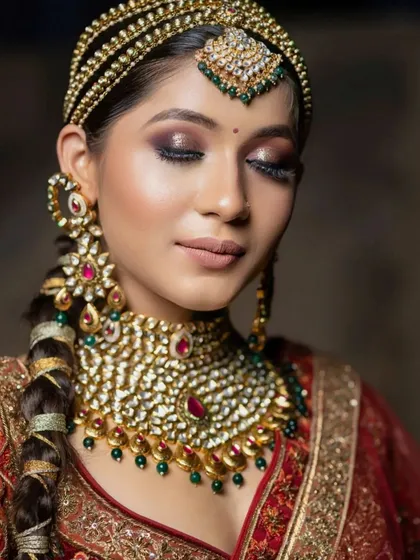 A beautiful shot with the bride's eyes closed, focusing on the rich, smokey eye makeup and the warm tones of her look.