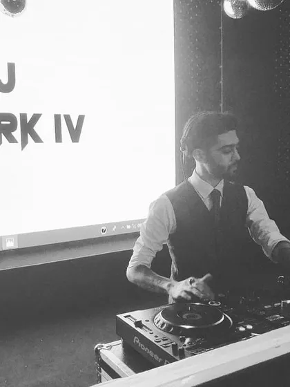 A candid shot of me at the console with my logo displayed on the screen behind me. This was taken during a corporate event where branding and a professional appearance were key.