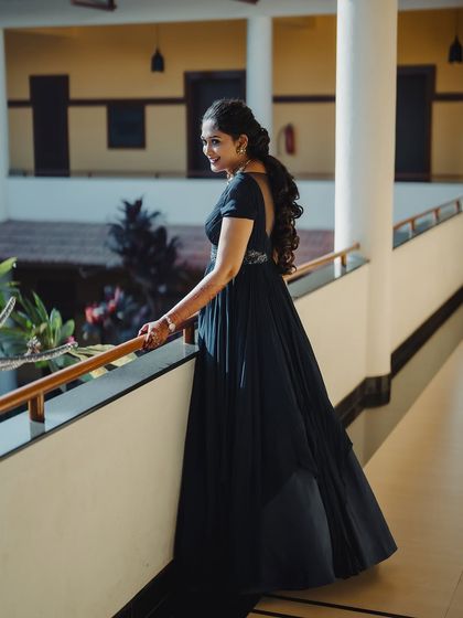 The full view of Surabhi's welcome event gown and hairstyle. The long, flowing dress is complemented by a voluminous ponytail, creating a very regal look.