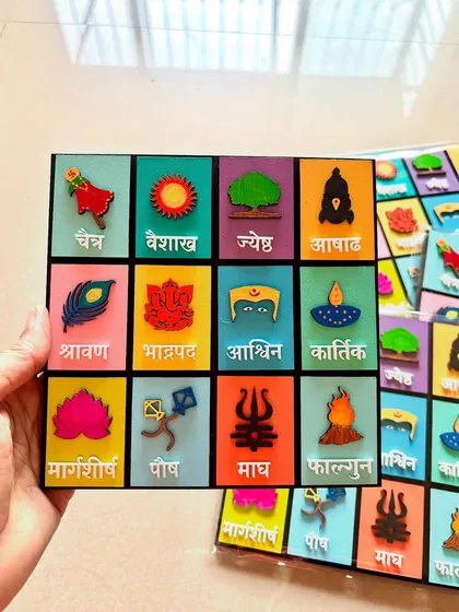 Holding the Marathi calendar to show its size and the 3D effect of the hand-painted wooden elements.
