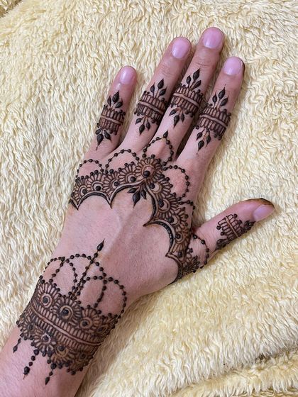 A jewelry-style henna design that looks like a delicate hand chain, perfect for parties.