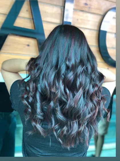This is a gorgeous example of deep violet highlights woven into dark, wavy hair. The color adds a touch of mystery and sophistication, creating a look that is both bold and elegant.