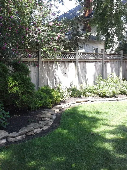 Another angle of a finished bed with a natural stone border. A well-defined edge between your lawn and garden beds makes mowing easier and looks professional.