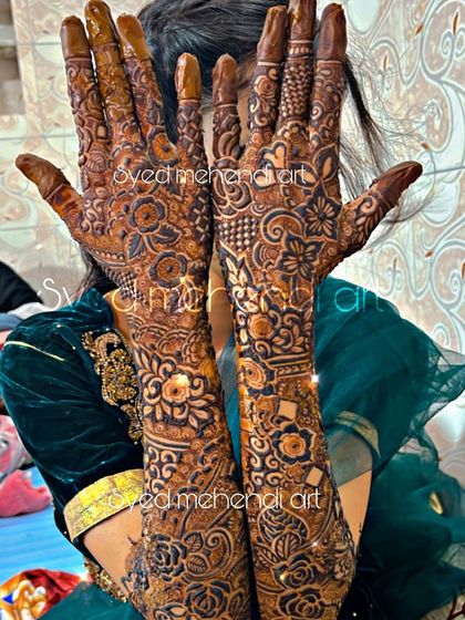 A full bridal design with the client hiding her face, putting the focus entirely on the henna.