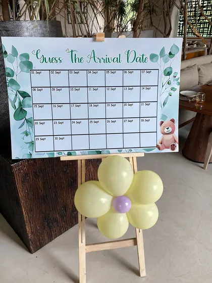 Interactive fun for a baby shower. We designed this 'Guess The Arrival Date' game board on an easel, decorated with a small balloon flower, to get guests involved in the celebration.