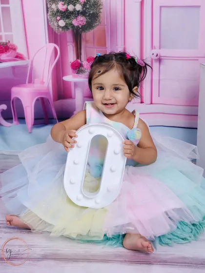 A perfect smile while holding the letter 'O'. These alphabet props are a fun way to personalize a first birthday shoot.
