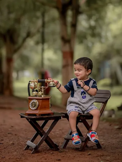 A curious glance as he reaches for the phone. I let children interact with props naturally, which leads to authentic portraits that truly reflect their inquisitive nature at this age.