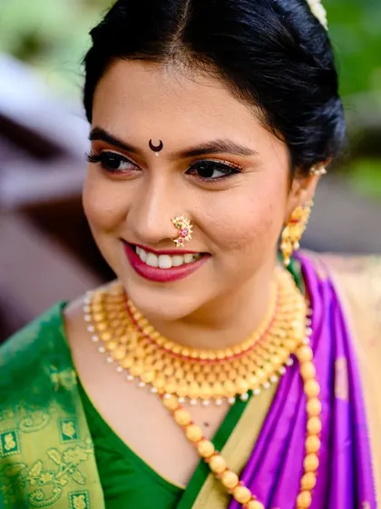 A close up portrait of Poorva that beautifully showcases her traditional Maharashtrian nose ring (nath) and gold necklace.