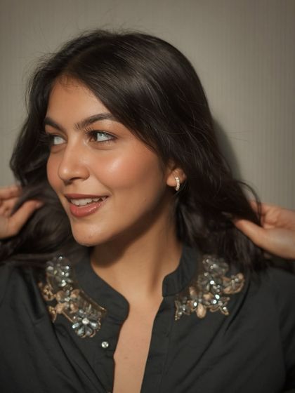 A simple black top with embellished shoulders, paired with minimal jewelry. This is a great example of an elevated casual look for a coffee date or brunch.