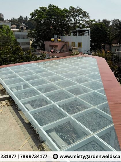 Another aerial shot showing the finished toughened glass roof with its elegant brown trim. The precision of the installation ensures a perfect fit and a flawless, weatherproof seal.