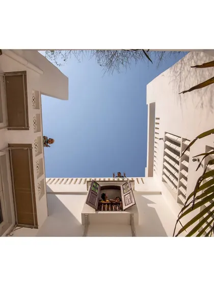 The deep plan of the building is pierced by whitewashed courtyards that bring daylight and fresh air down to the basement level. These courtyards are the lungs of the building, allowing for natural ventilation and evaporative cooling.