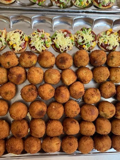Trays of mini pizzas and corn cheese balls, freshly made for a party of 40. Bite-sized snacks are perfect for mingling.