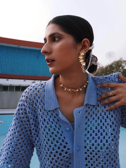 Another portrait from the Rasti India shoot, highlighting the unique ear cuff and jewelry against the crochet shirt. It's all about the unexpected details.
