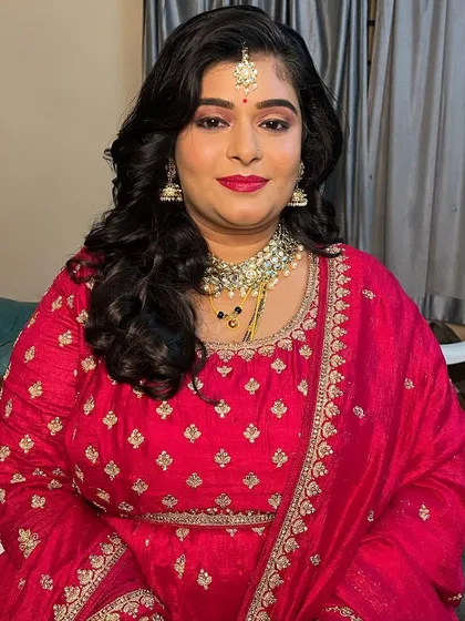 A full portrait of Divya's reception look. The rich red color of her outfit is perfectly complemented by the glamorous makeup.