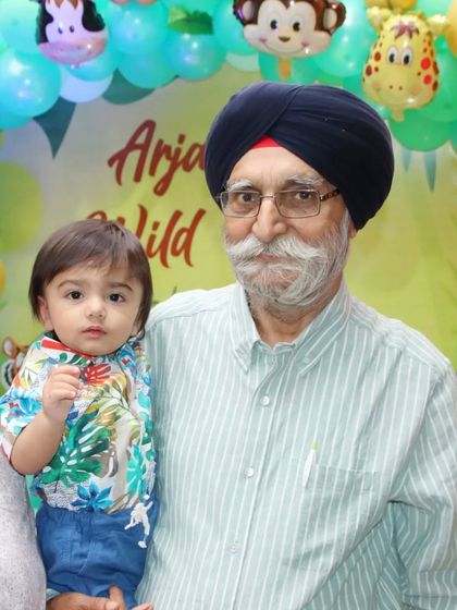 A heartwarming portrait of a grandfather holding his young grandson at a family event.