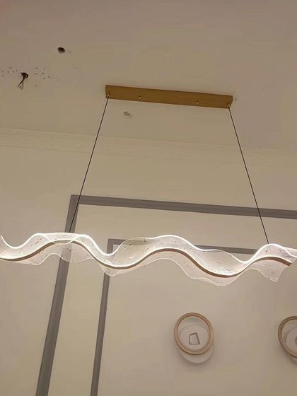 A close-up of the 'Waves of Elegance' linear pendant in our showroom. The textured acrylic creates a beautiful, shimmering effect.