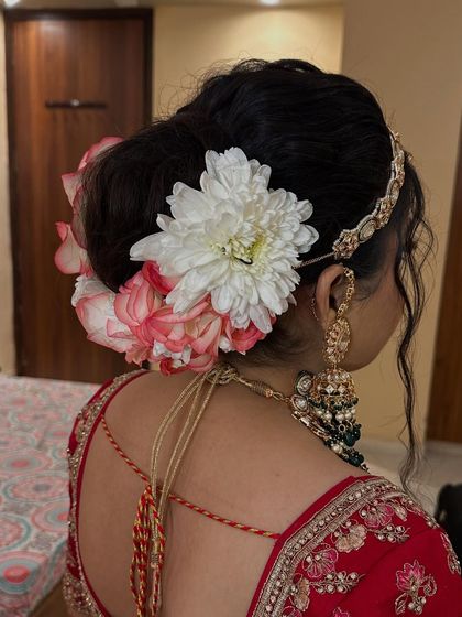 A side view of a floral bun, showing how the flowers are placed to complement the bride's jewelry and outfit.