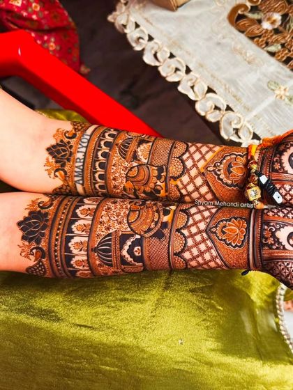 A close-up of the forearms, showing intricate bands of traditional patterns and a personalized name.