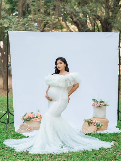 Using a simple white backdrop outdoors gives us the best of both worlds: the clean look of a studio and the beautiful, soft light of nature. This mom-to-be looks absolutely radiant in her elegant white maternity gown.