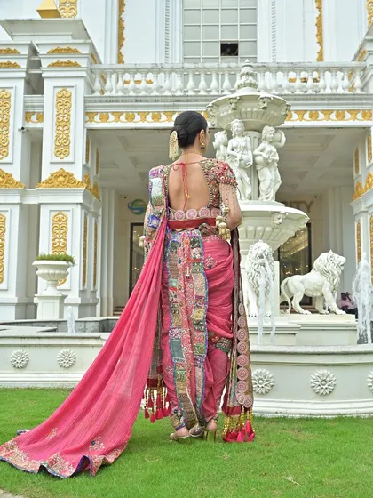 The back view of this pink Nauvari saree shows the intricate draping style and the detailed embroidery on the blouse.