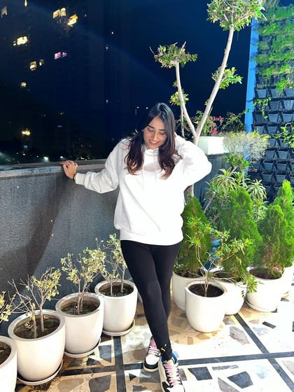 Looking down, showing the relaxed fit of the hoodie. This highlights the comfort aspect of the outfit.