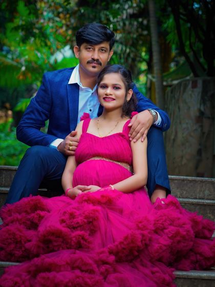 A beautifully composed portrait of a couple sitting on outdoor steps. The vibrant color of the gown contrasts with the natural setting, making them the clear focus of the image.