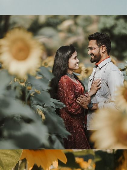 A sweet moment between a couple in a sunflower field, their coordinated outfits adding to the visual harmony.