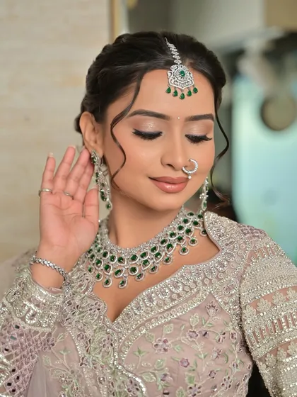 A close-up showing the flawless makeup and the intricate design of the diamond and emerald choker.