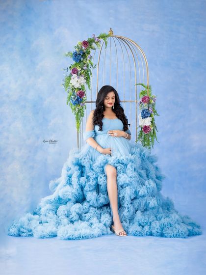 A serene pose, seated in the floral birdcage, this portrait is the epitome of grace and elegance.
