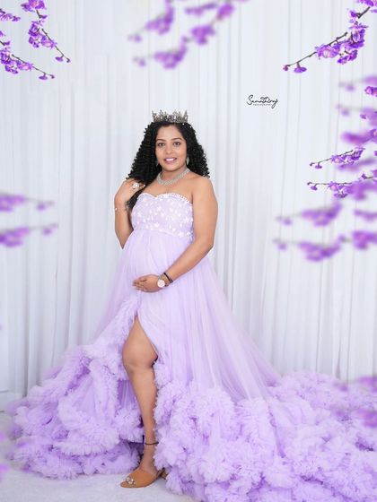 A glamorous portrait of a mother-to-be in a lavender gown and tiara. The slit in the dress and her confident pose add a touch of modern style to this fairytale look.
