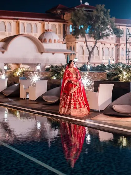 A bride standing by the water, her reflection as timeless as the palace behind her. This is a portrait of elegance, capturing the grandeur of a destination wedding.