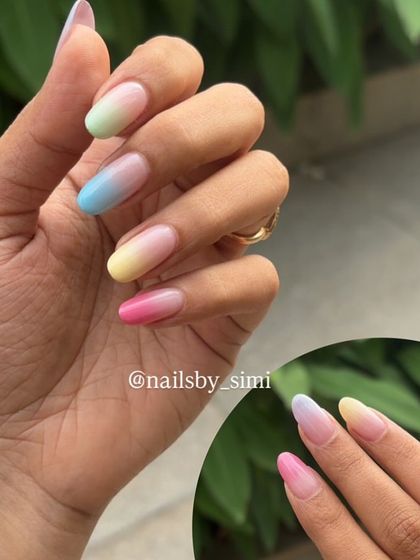 I love how these colorful ombre nails look against a natural background. Each nail has a different soft pastel gradient, from pink and yellow to blue and lavender.
