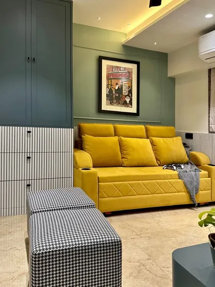This media room is designed for fun and relaxation, with a comfortable yellow sofa-bed, houndstooth-patterned ottomans, and a cool-toned color scheme of sage green and deep teal.