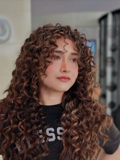 For my clients with curly hair, it's all about making each curl pop. I hand-painted highlights to define her natural texture, creating depth and dimension while keeping the curls healthy and bouncy.