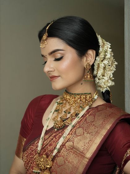 With eyes gently closed, you can see the soft, shimmering eyeshadow work. I use tones that enhance the richness of the bridal attire, creating a look of serene elegance.