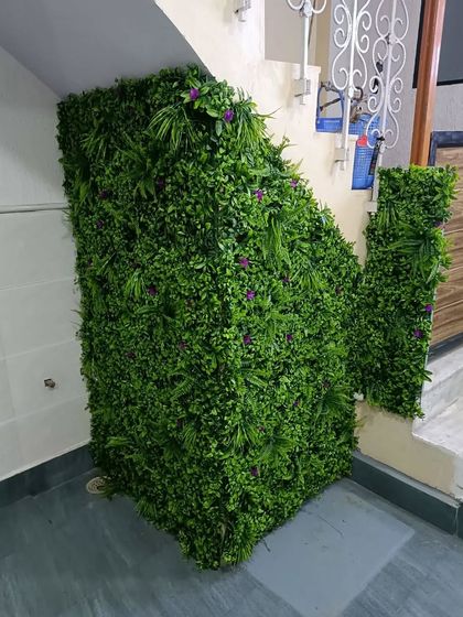 For this staircase, we used artificial green wall panels to completely cover the awkward side wall. This instantly hides any imperfections and creates a continuous wall of green that flows up alongside the stairs.