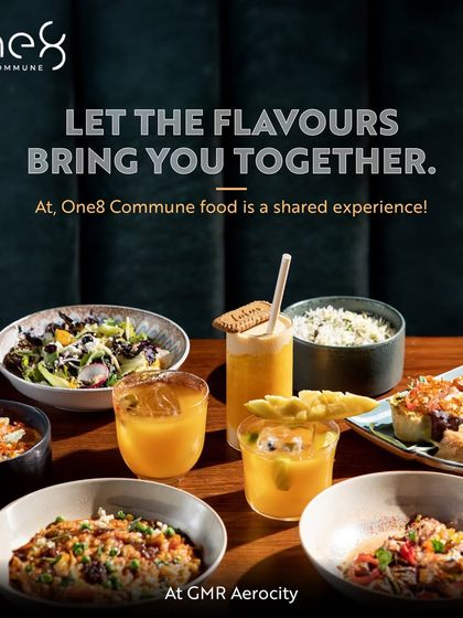 At One8 Commune, food is a shared experience that brings people together. This image displays a vibrant spread of global dishes and drinks, perfect for a communal feast.