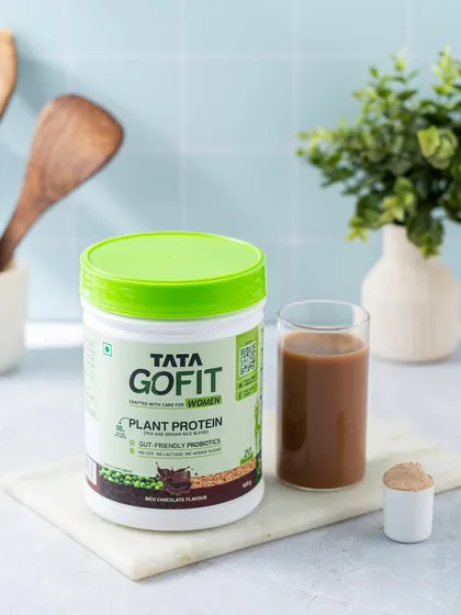 A kitchen counter scene showing the prepared protein shake next to the Tata GoFit tub, providing a clear visual of the product before and after preparation.