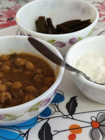 A balanced meal of chana masala (chickpea curry), a side of vegetables, and curd. This provides a good mix of protein, fiber, and probiotics.