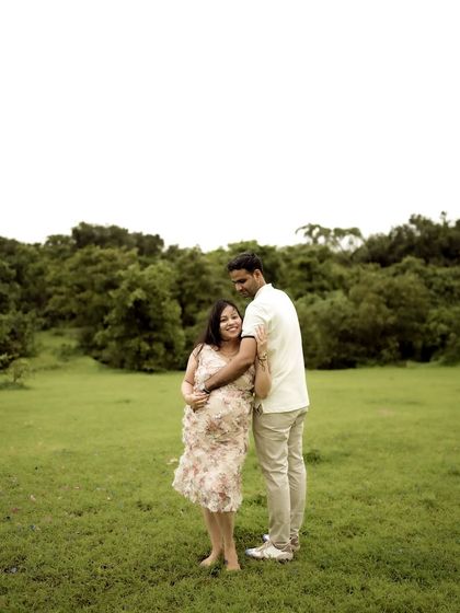A classic portrait of the couple embracing in a wide-open field. Their happy expressions and the beautiful scenery make for a perfect maternity photo.