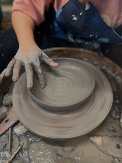 The blur of the wheel and the focus of the hands. This is the energy of creation, turning soft clay into a beautiful, functional plate.