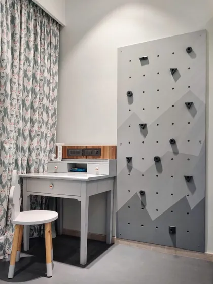 I believe a child's room should be a place for both rest and adventure. Here, I designed a custom indoor climbing wall for active play, right next to a simple, elegant study desk for quiet, creative moments.