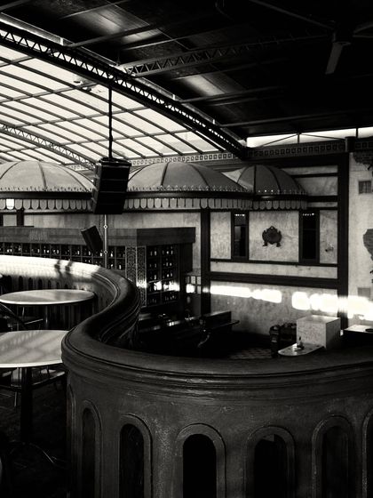 A dynamic view of the curved balcony and the bar canopies, showcasing the interplay of the major architectural forms in the space.