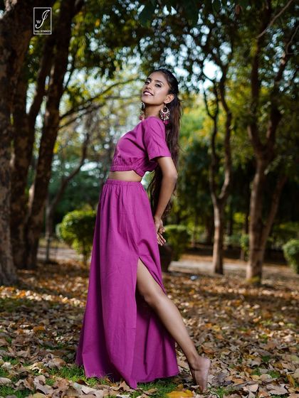 A cheerful and energetic portrait, capturing the model's smile and the flattering silhouette of the co-ord set among the fallen leaves.