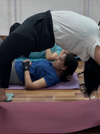 This student demonstrates a deep, chair-assisted backbend, opening the chest and shoulders while feeling fully supported.