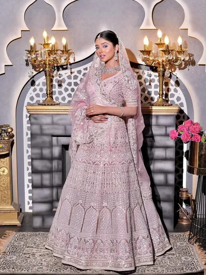 A full-length portrait showcasing the stunning details of the bride's pink lehenga. The makeup is designed to be equally grand, ensuring she looks like royalty from head to toe.